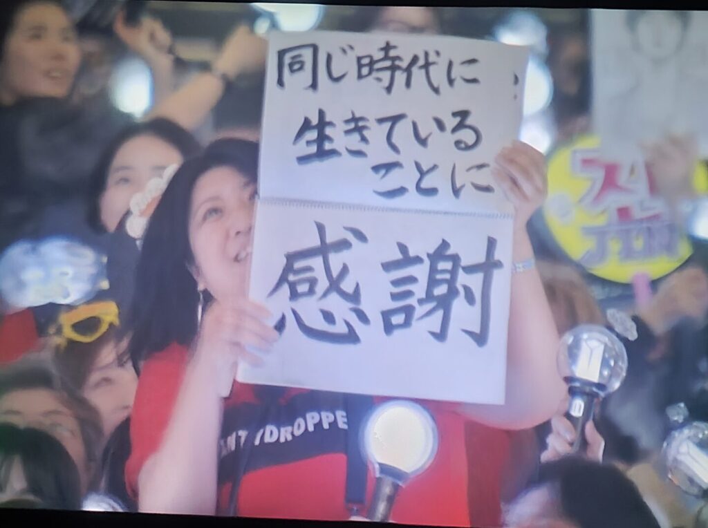 ARMY holding a fan sign in the Japanese language